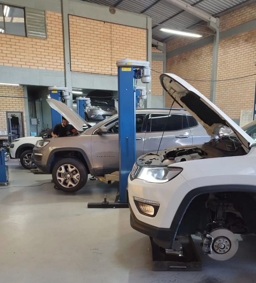 Interior da oficina da R3 com Jeeps em atendimento